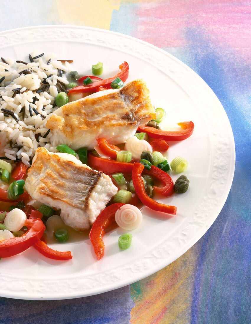 Close-up of coley fillet with rice and peppers on plate