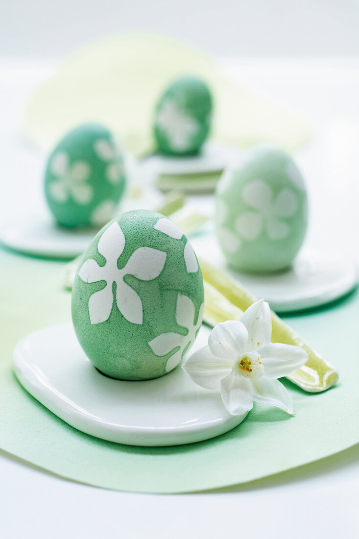 Close-up of Easter eggs with floral print next to white flower