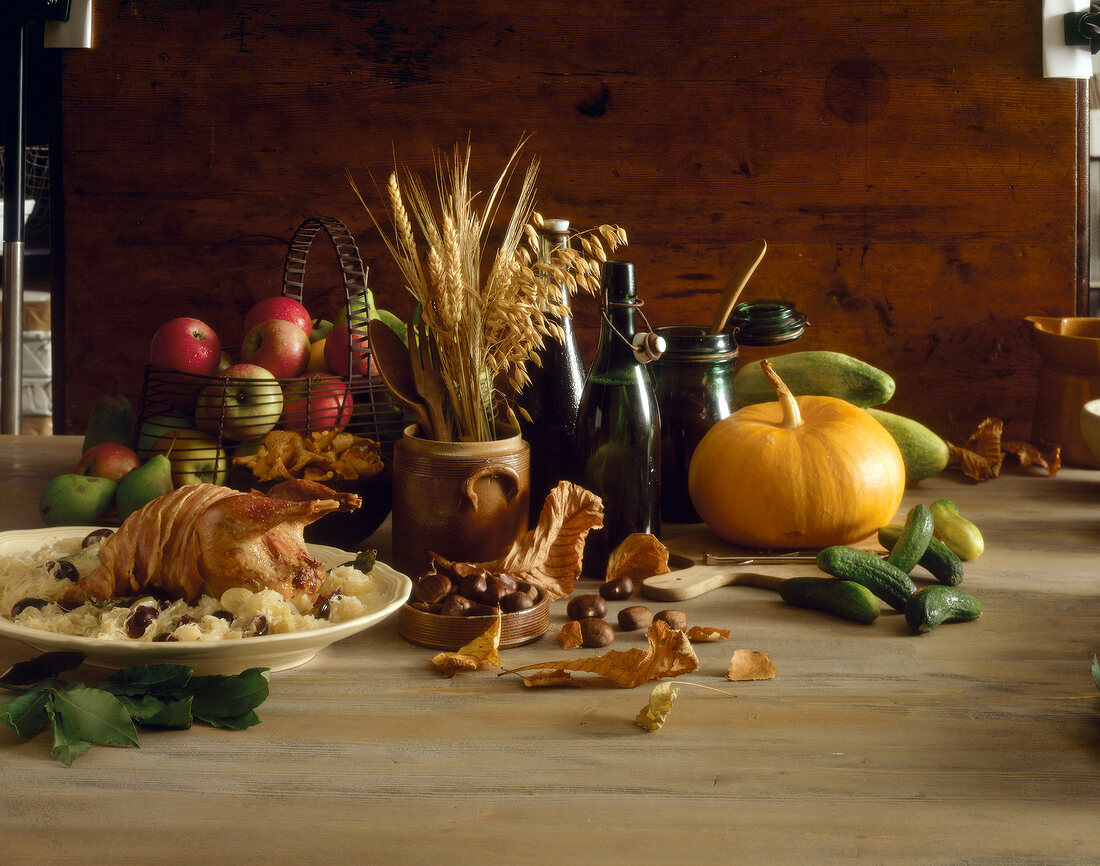 Baked pheasant on sauerkraut beside cucumbers, pumpkin and chestnuts