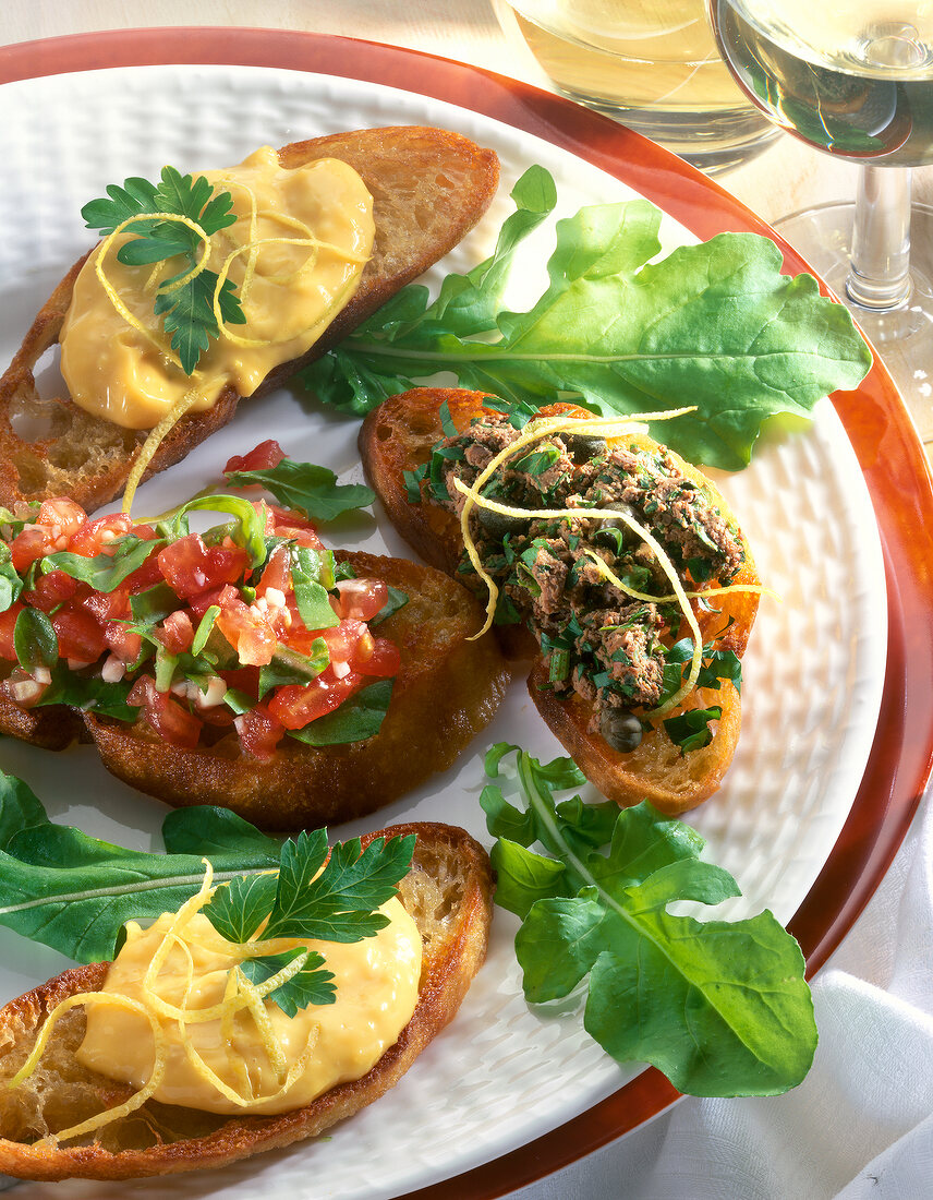 Close-up of crostini with chicken liver, ailoi and tomatoes on plate