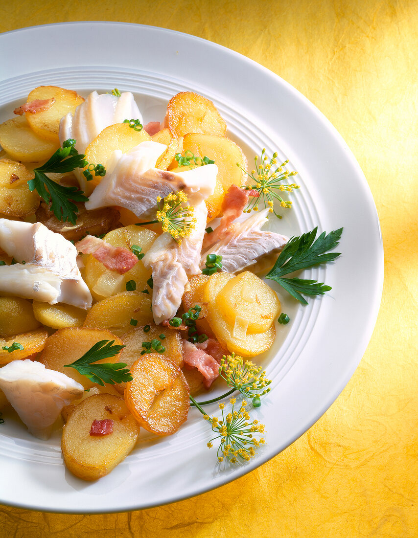 Close-up of fish fillet and fried potato on plate