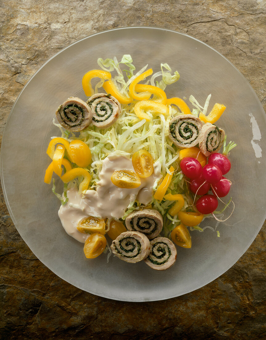 Close-up of iceberg lettuce with peppers and schnitzel rolls on plate