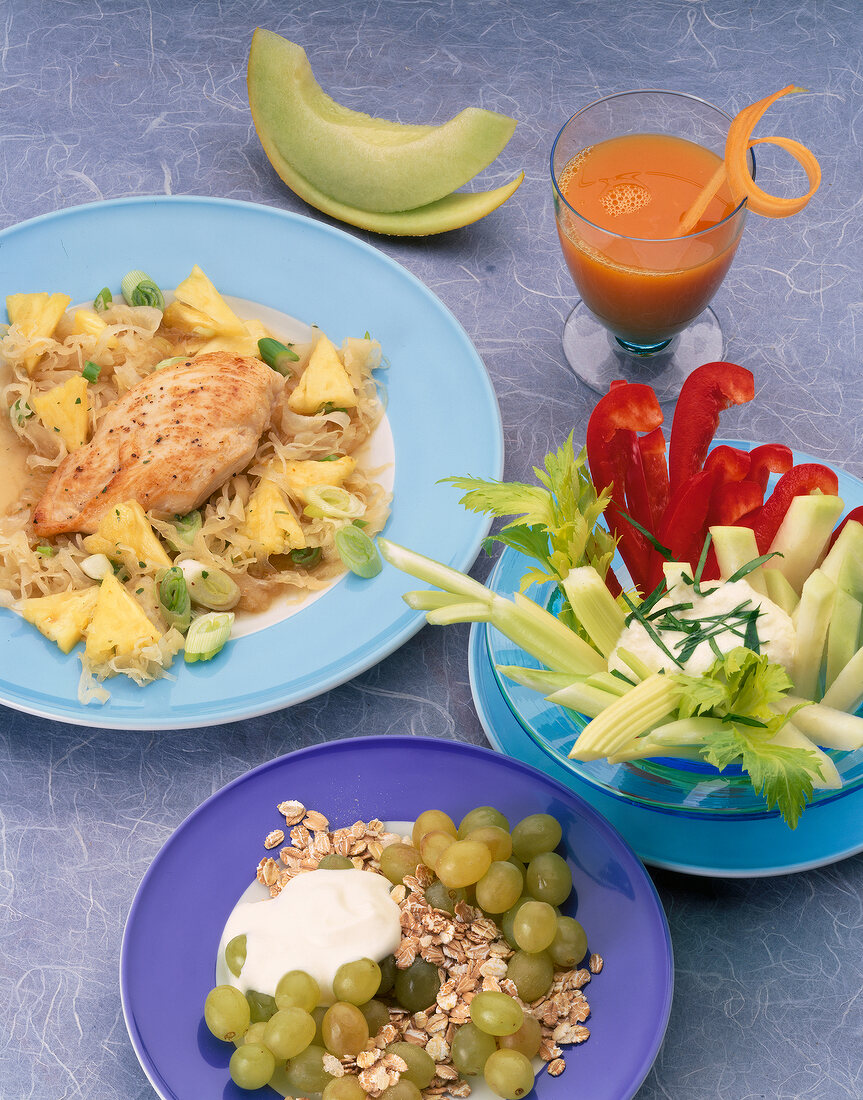 Chicken breast with cabbage, cereals, vegetables on plates with carrot juice