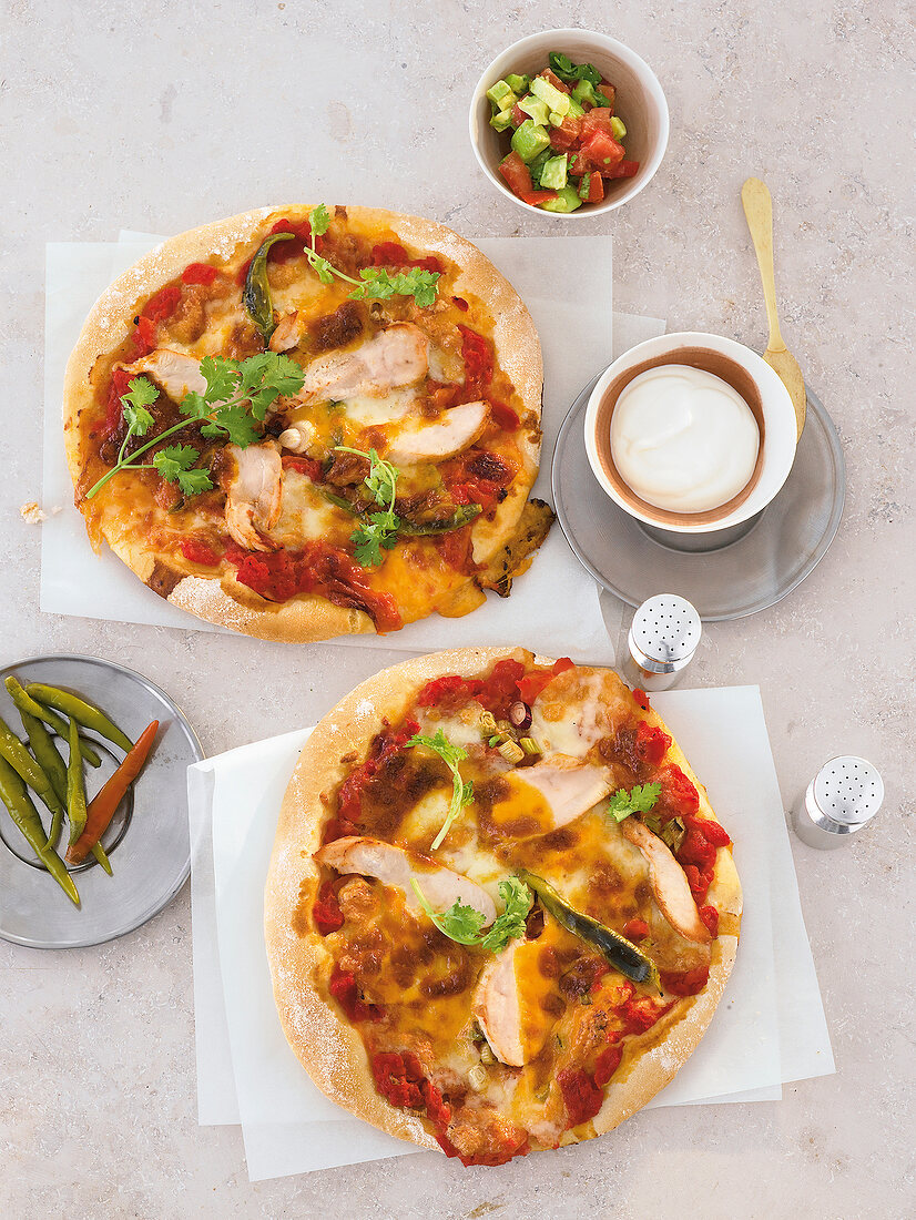 zwei kleine runde Pizzen Mexican Style mit scharfem Hähnchenfleisch