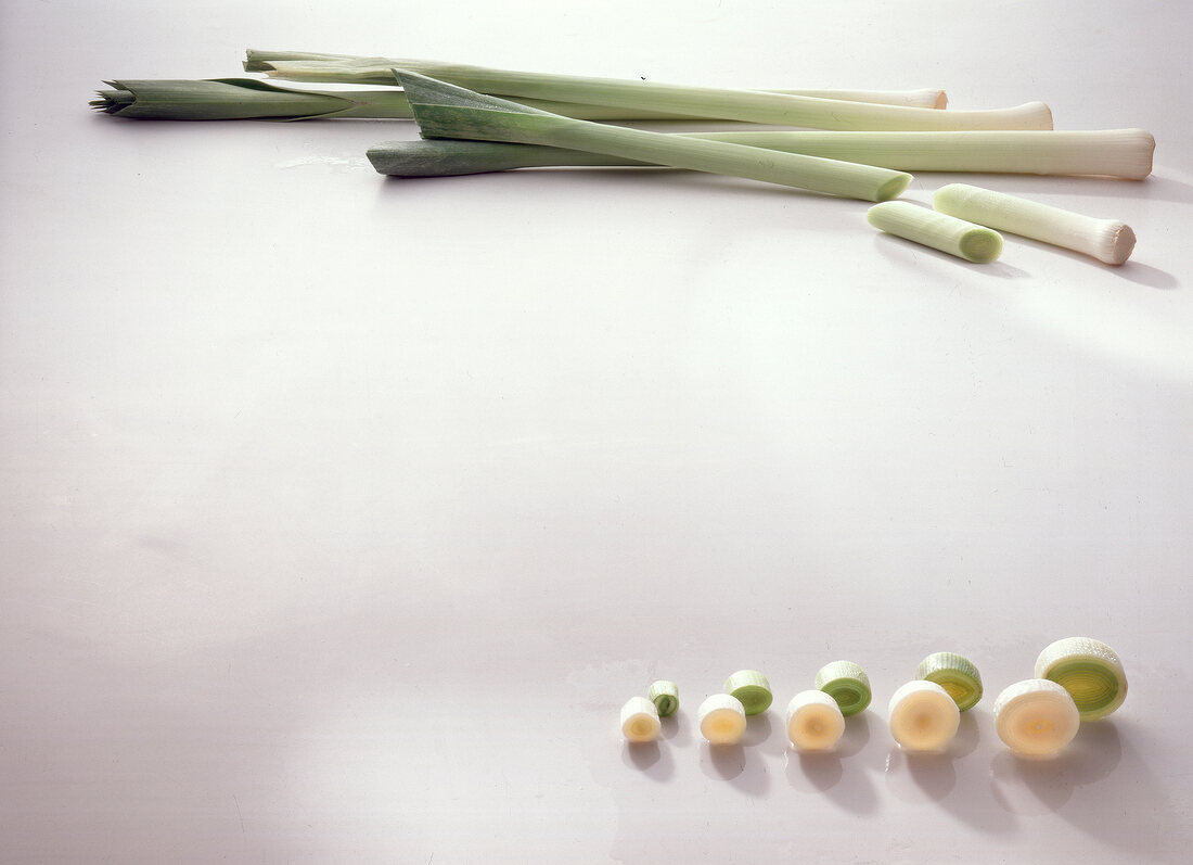 Whole and sliced leeks ??into rings on white background