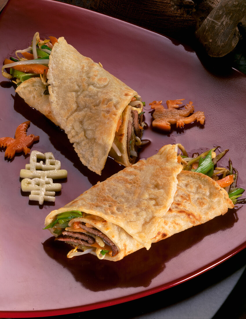 Close-up of pancake filling with vegetables on red plate