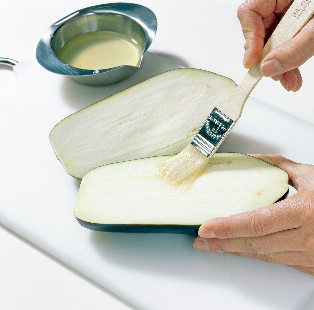 Close-up of applying lemon juice on eggplant with brush, step 3