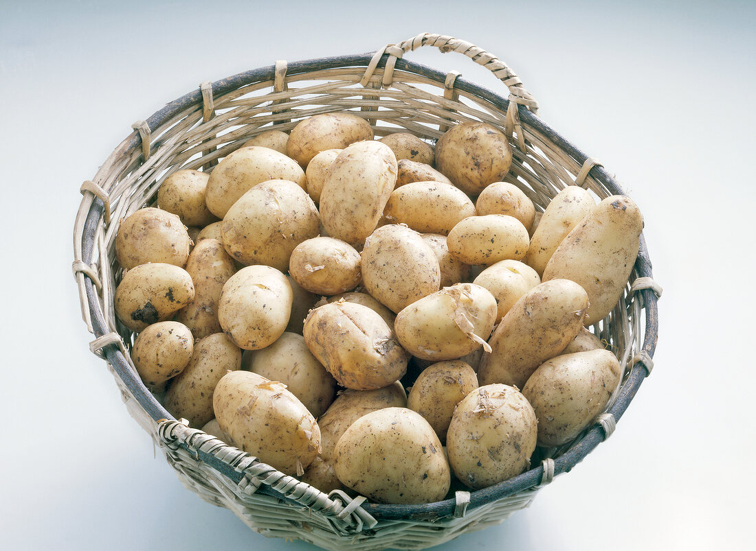 Close-up of potatoes in basket on white background