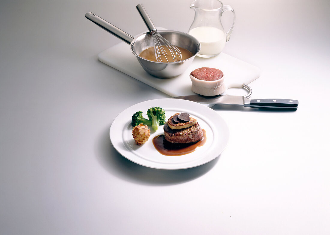 Beef with broccoli on plate and ingredients on chopping board