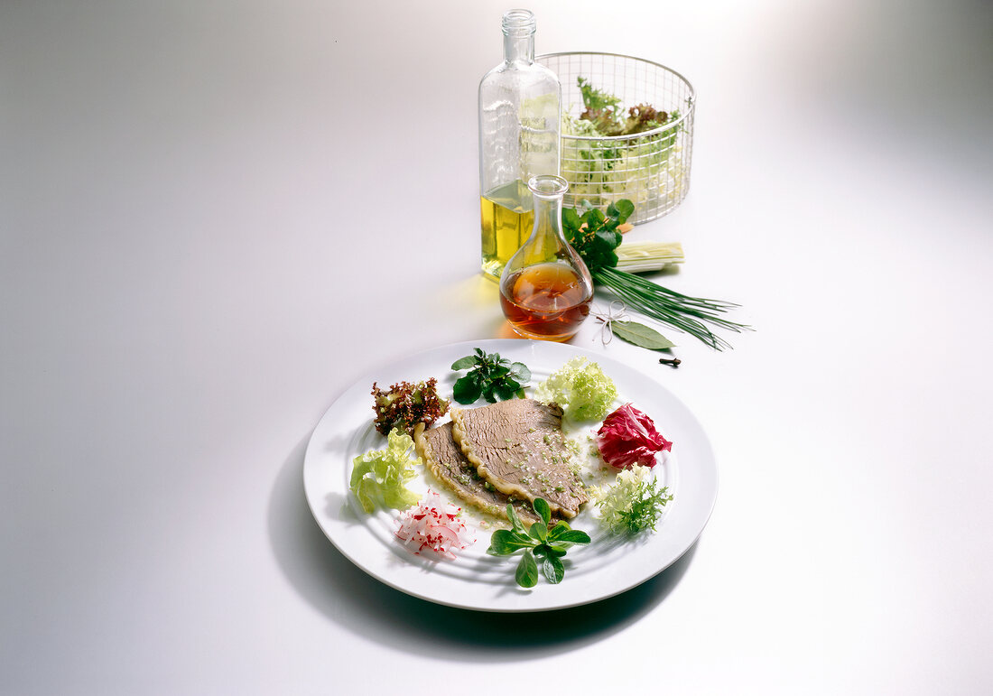 Boiled beef with chive vinaigrette and salad wreath on plate