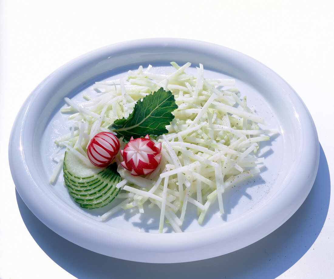 Kohlrabi salad with radishes and cucumber on plate