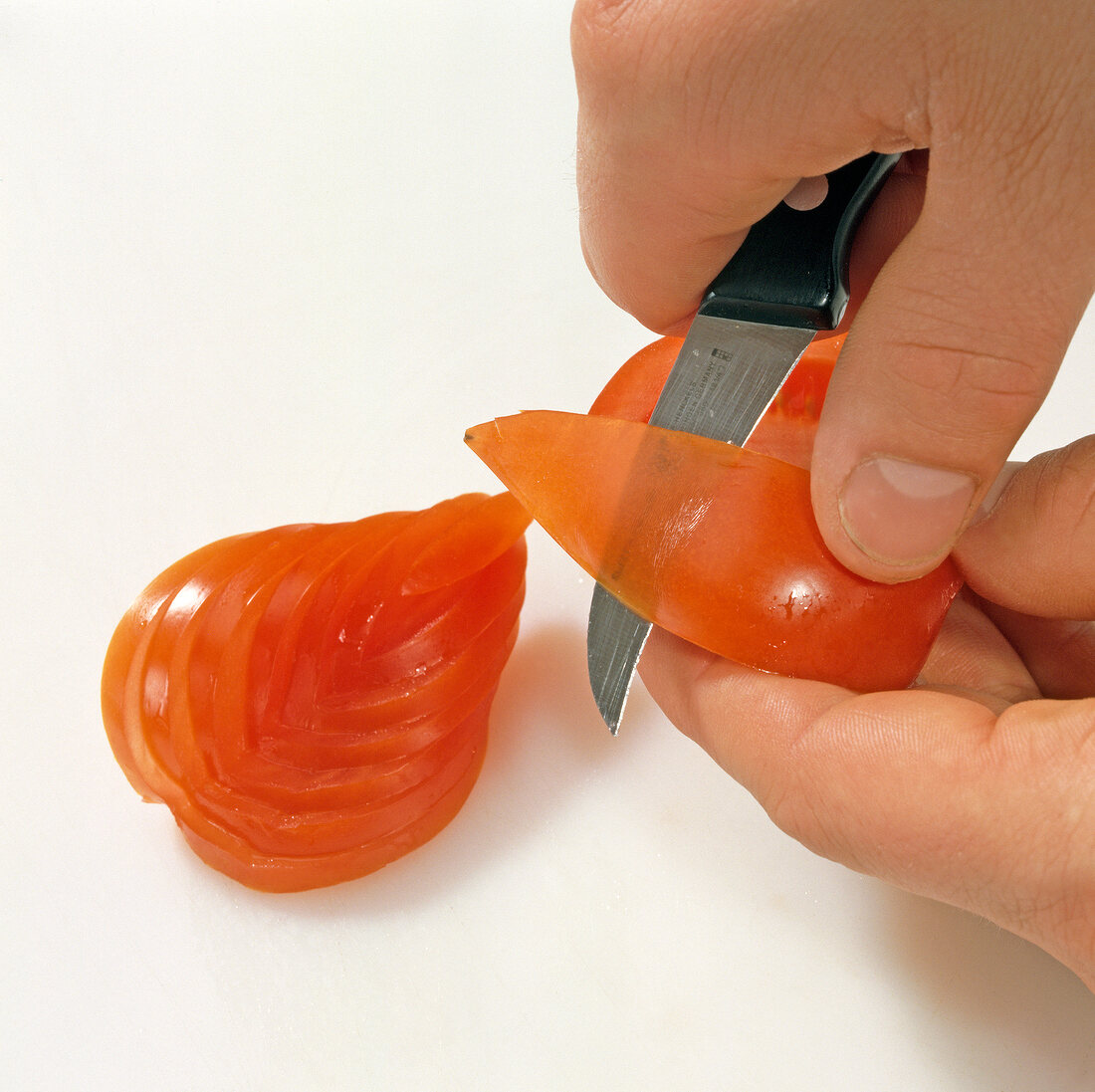 Close-up of tomato being carved for decoration, step 2