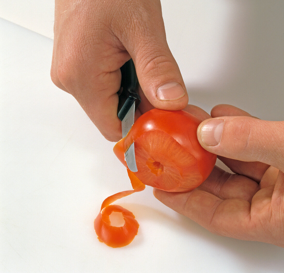 Close-up of tomato being peeled for decoration, step 1