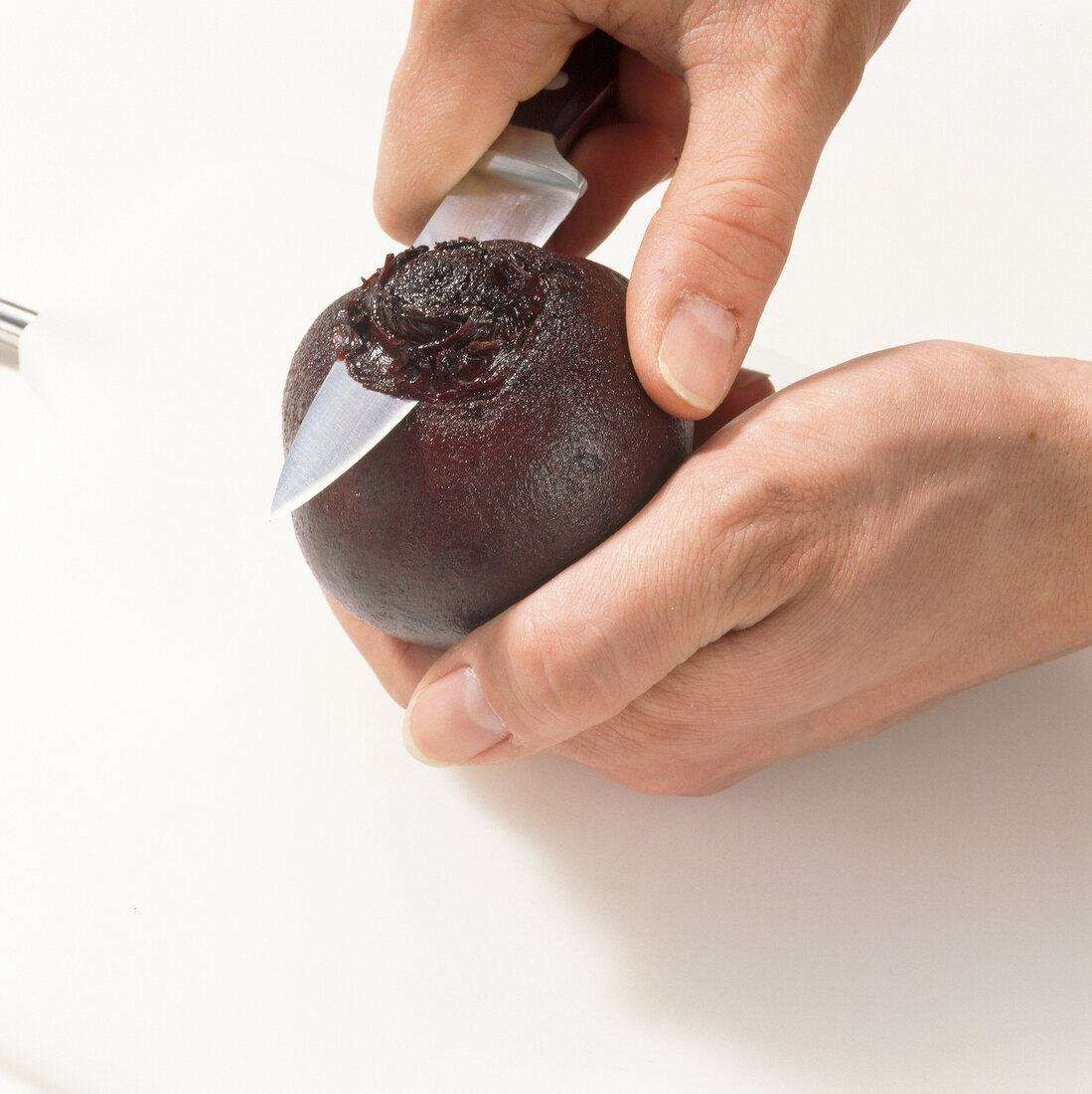 Close-up of hands cutting ends of beetroot, step 1