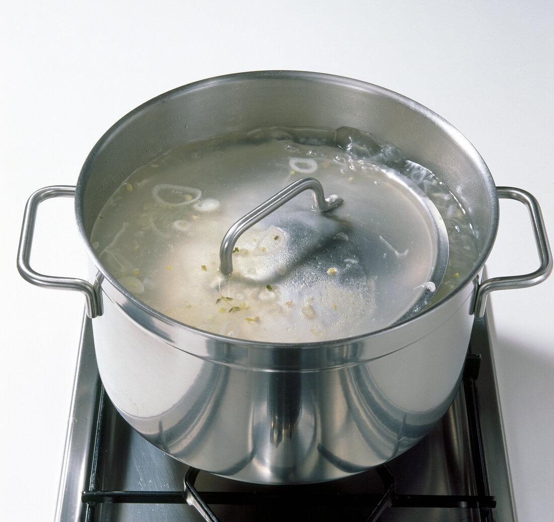 Pot of boiling water on stove with small lid, step 9