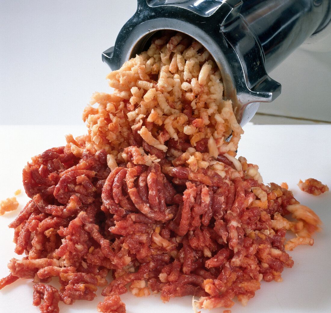 Meat being passed through meat grinder, step 4