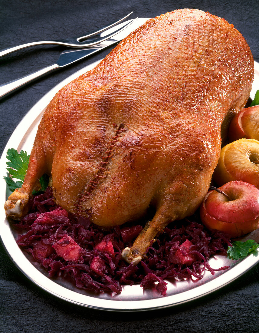 Goose in classic style with apple red cabbage and apples filled on serving dish