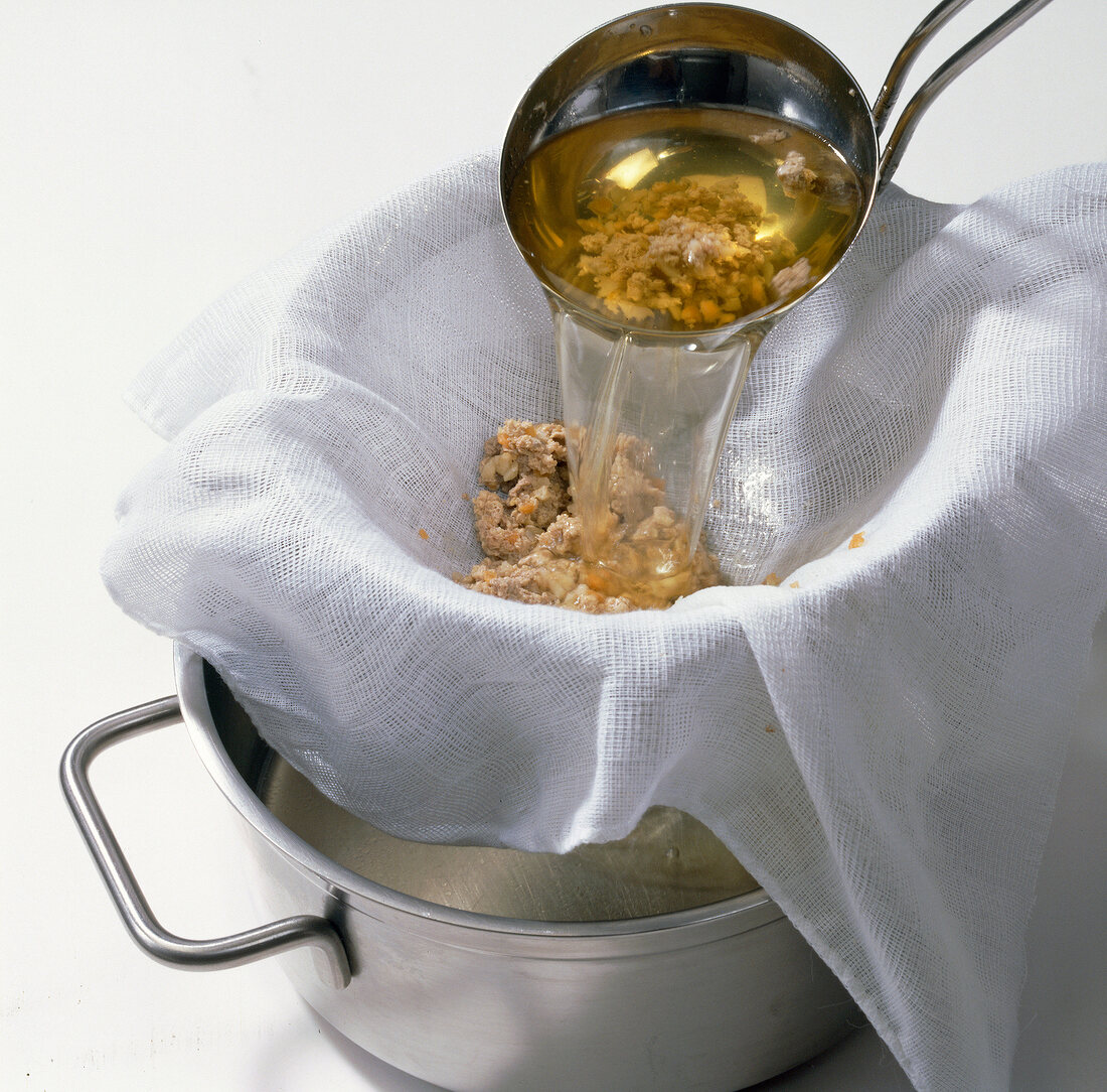 Passing beef broth through sieve with white cloth, step 9