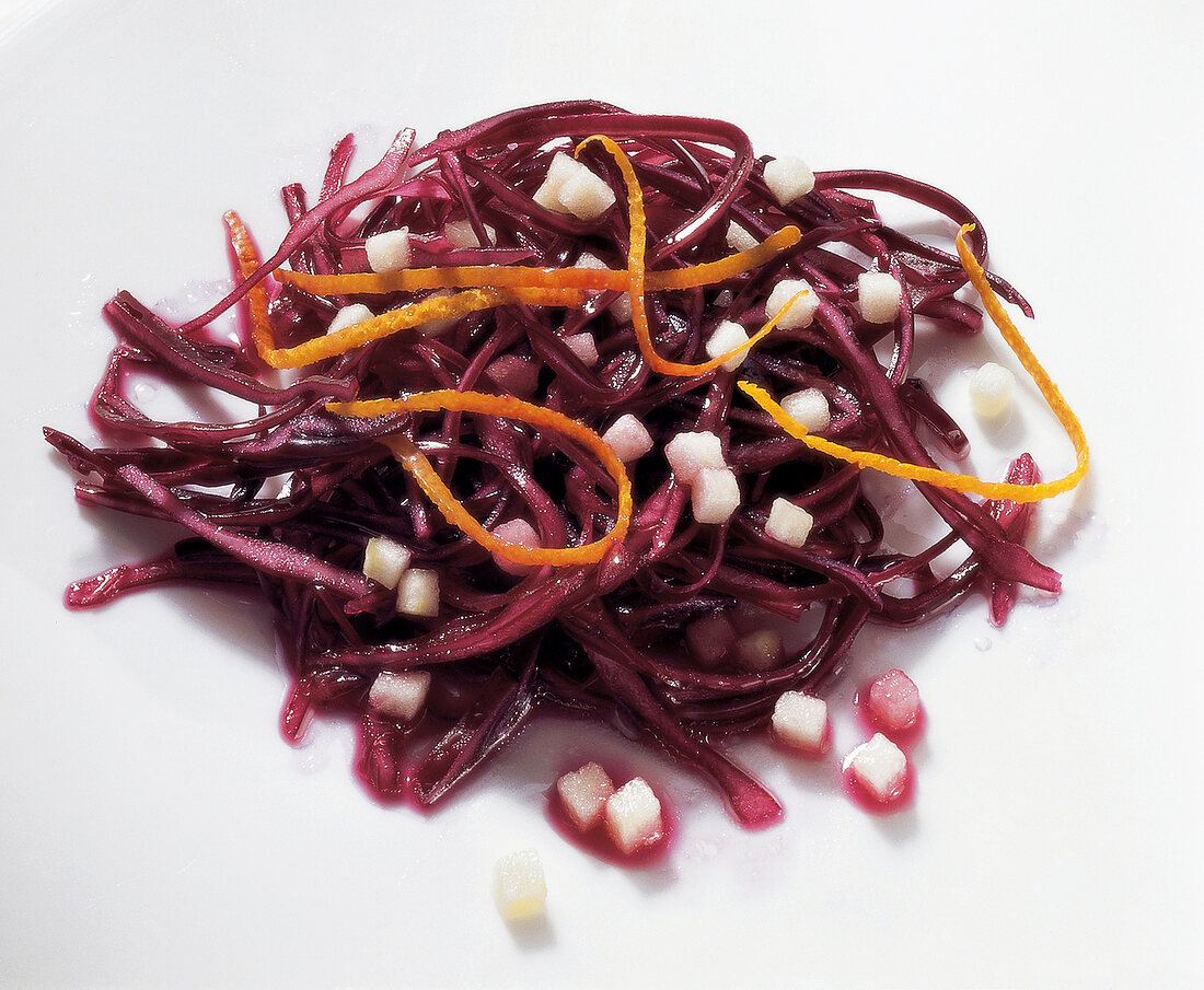 Close-up of red cabbage salad with apple on white background