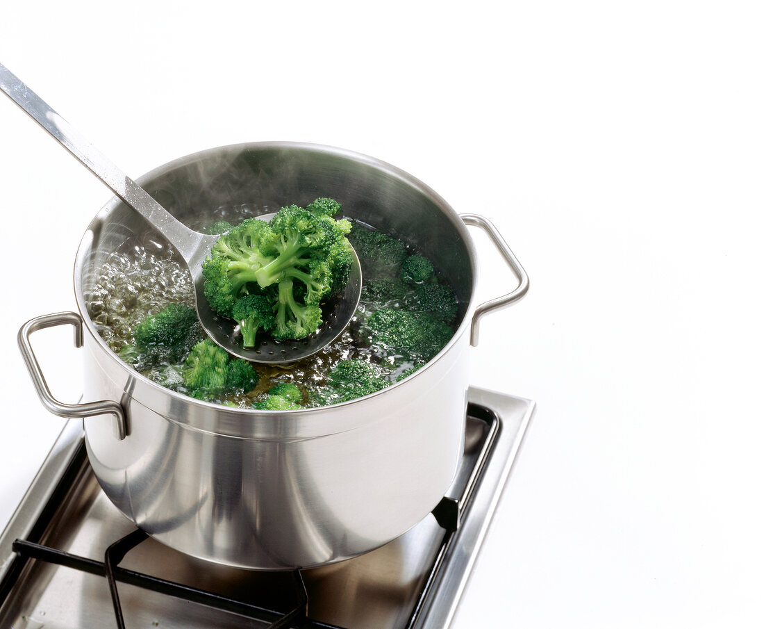 Close-up of broccoli being cooked in water with ladle