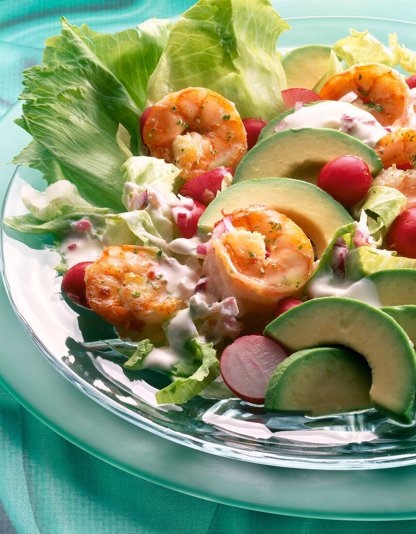 Eisbergsalat mit Kräuter-Garnelen und Avocado auf Teller, grün