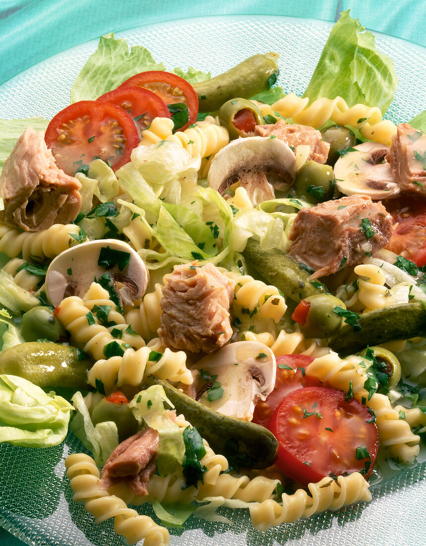 Close-up of pasta salad with tuna, tomatoes and mushrooms on plate