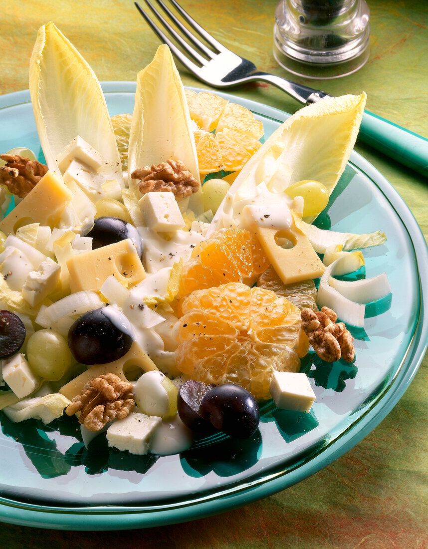 Close-up of chicory cheese salad with mandarin oranges and grapes on plate
