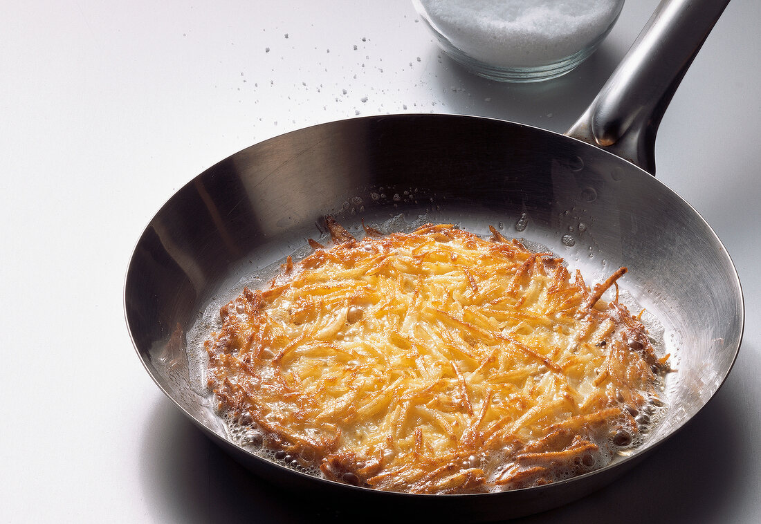 Hash browns in pan with sugar in glass