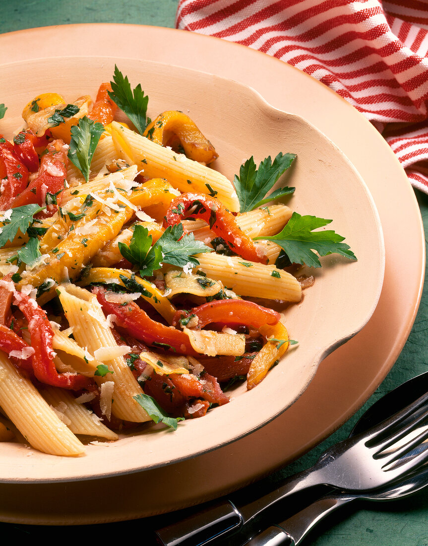 Close-up of penne pasta with peppers on plate