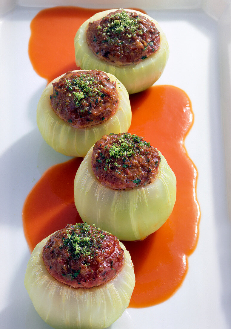 Close-up of stuffed kohlrabi and tomato sauce on white plate