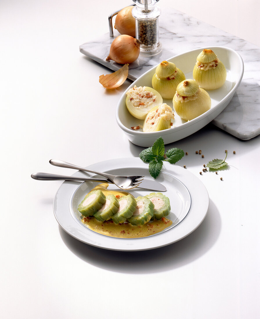 Stuffed onions in bowl and bitter gourd with curry sauce on plate