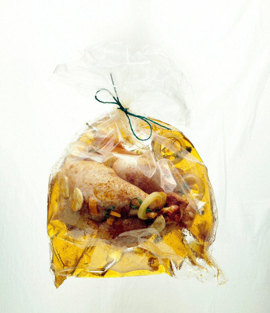 Close-up of chicken marinade in freezer bag on white background