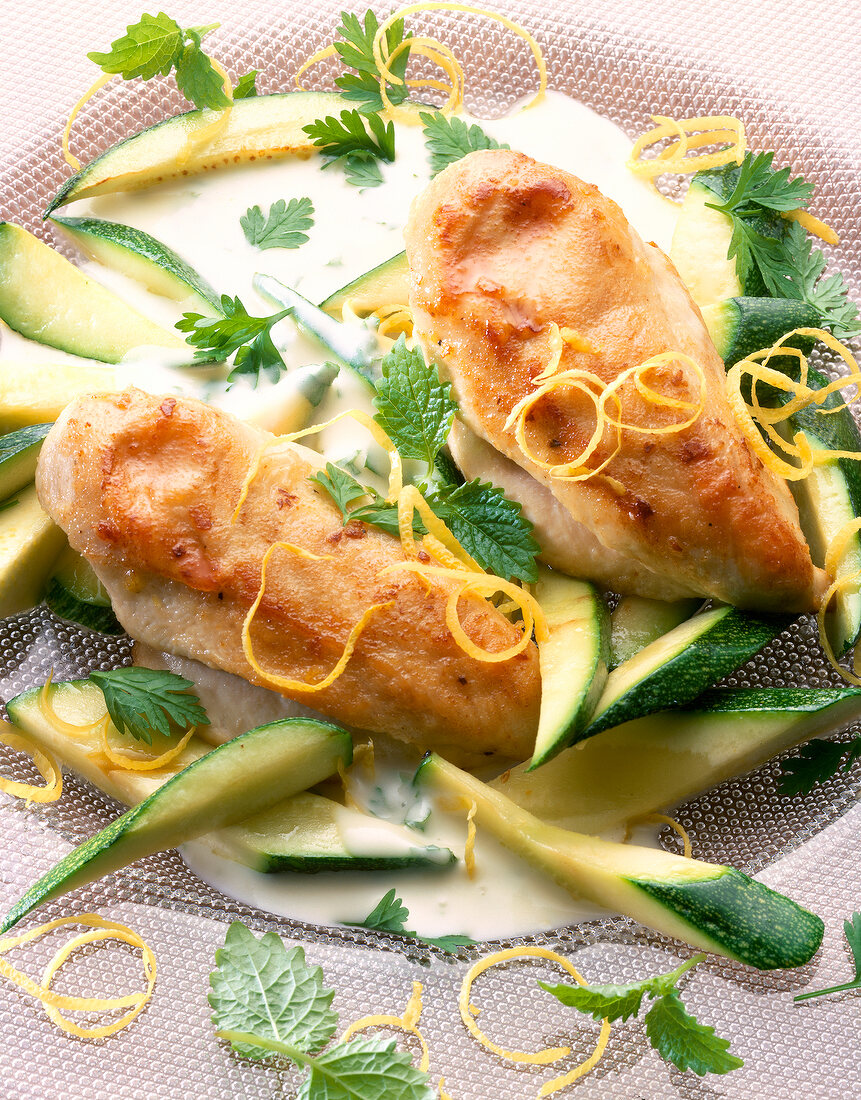 Close-up of chicken breast fillet with zucchini on plate