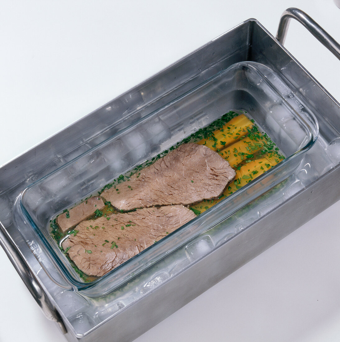 Slices of beef in glass bowl for preparation of aspic, step 4