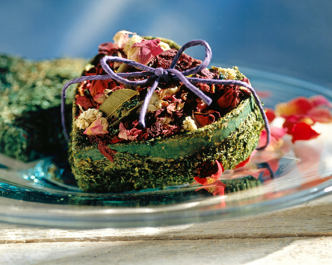 Close-up of dried flowers in heart shaped box tied with ribbon