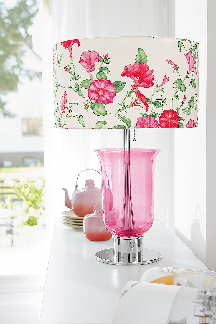 Pink floral table lamp on white sideboard