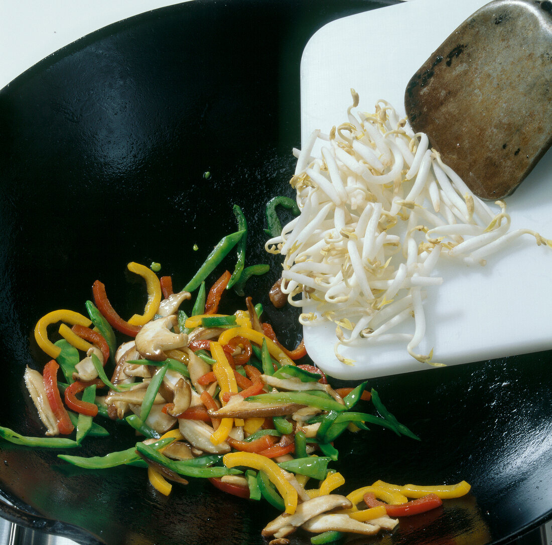 Adding bean sprouts to wok with vegetables, step 3