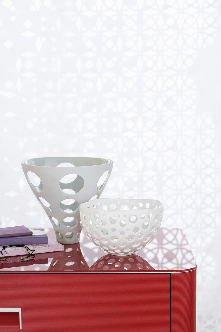 Close-up of three bowls on red cabinet