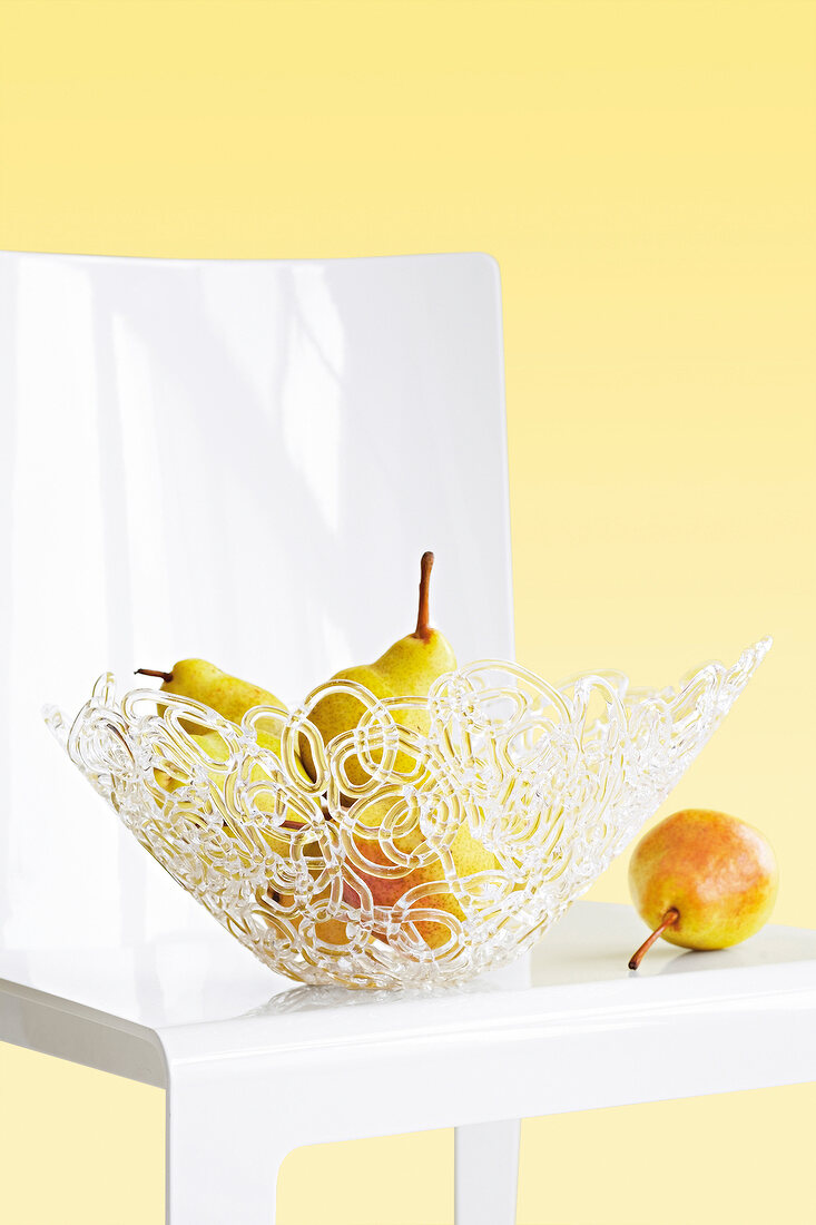 Close-up of glass bowl with pear on table