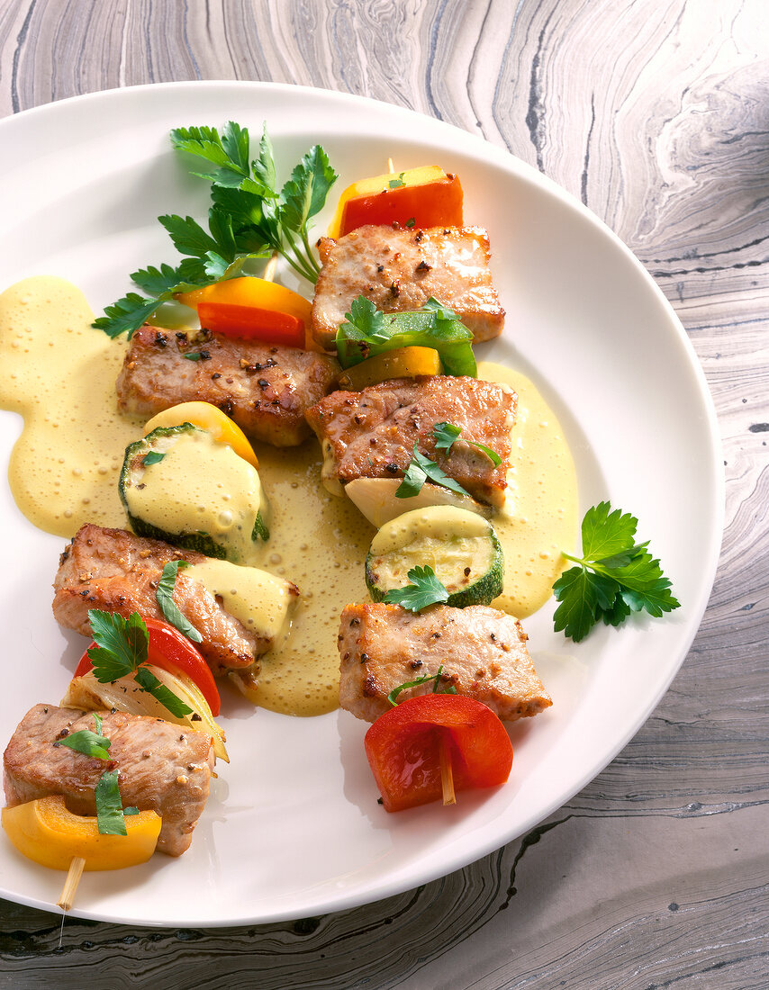 Fleischspieße aus Schweineschnitzel und Zucchini mit Currysauce