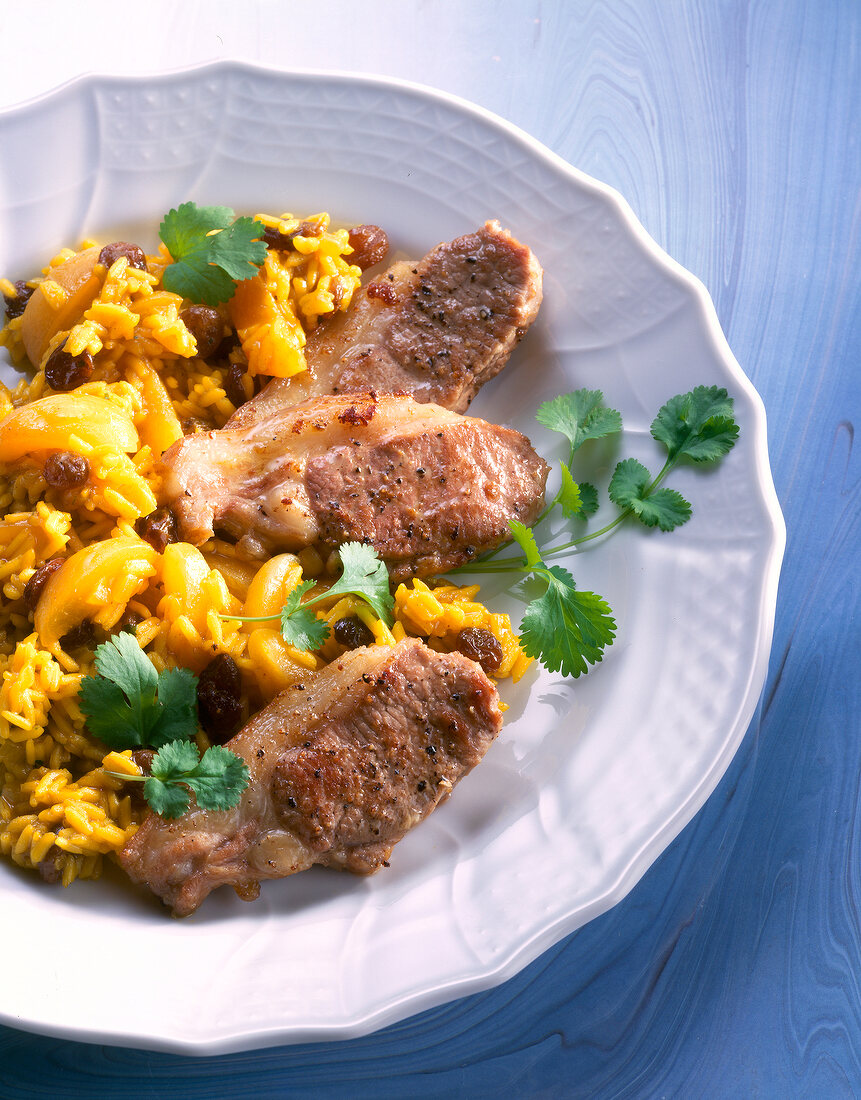 Close-up of lamb chops with raisin rice on plate