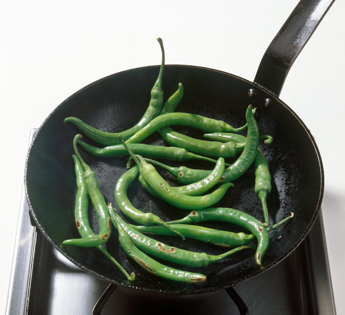 Paprika, grüne Chilischoten werden in Pfanne geröstet Step 1