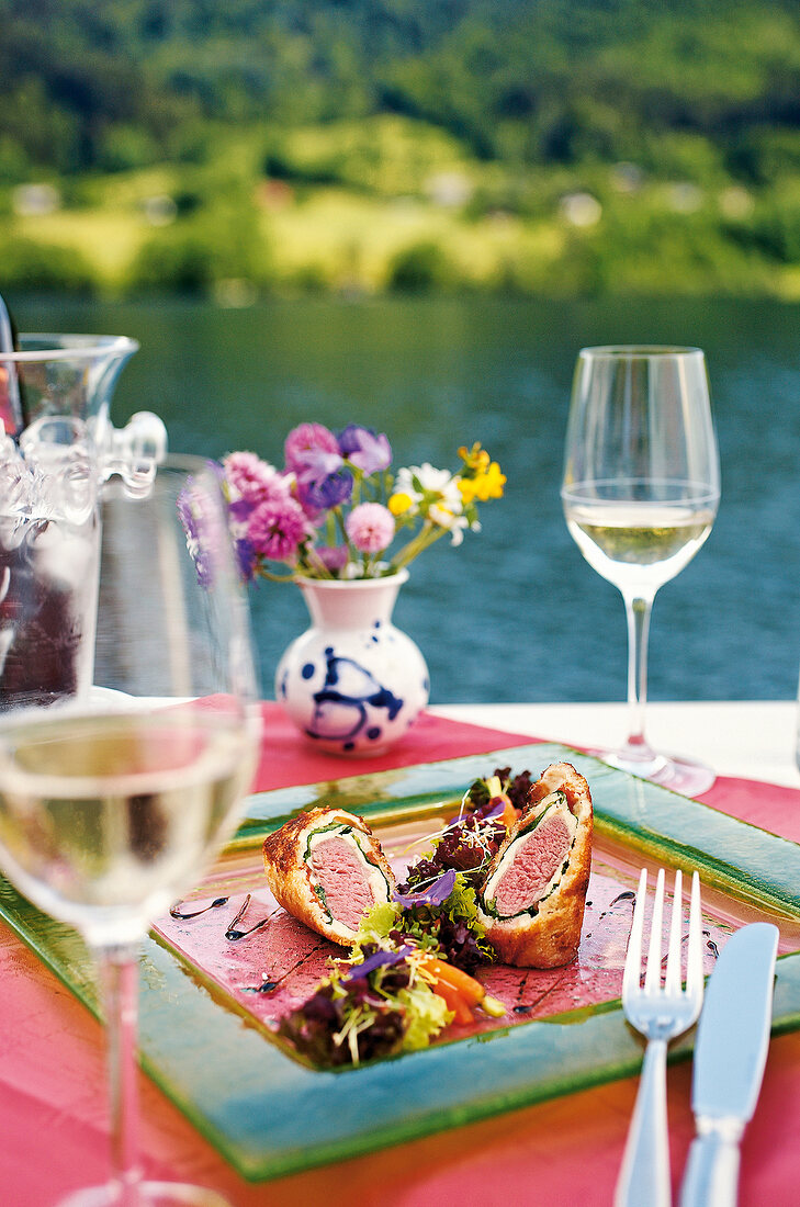 Close-up of venison fillet with pastry and salad in serving dish