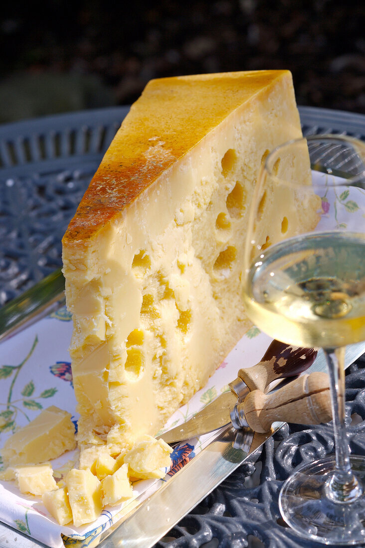 Ein großes Stück Schweizer Emmentaler und ein Glas Weißwein