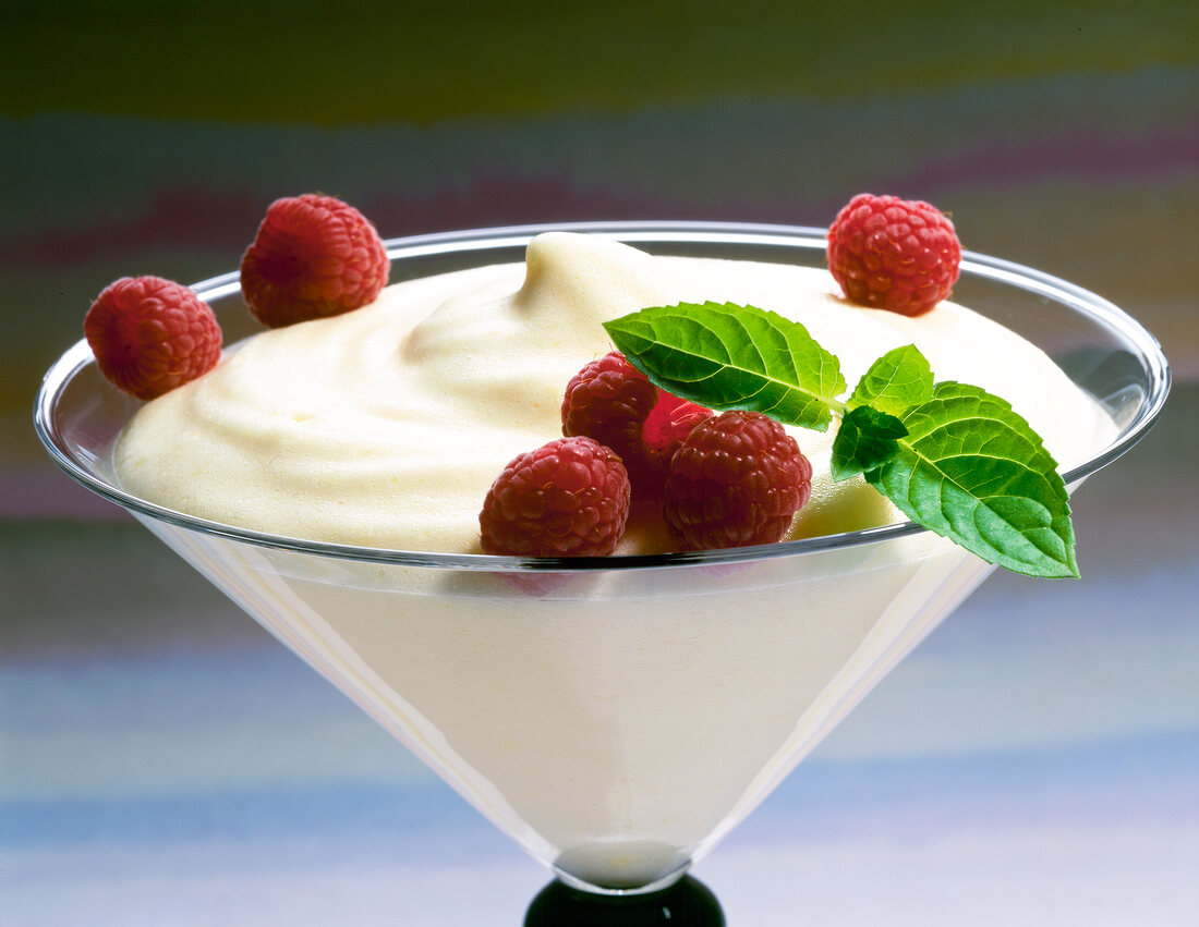 Close-up of foam cream of melon with raspberries in a dessert glass