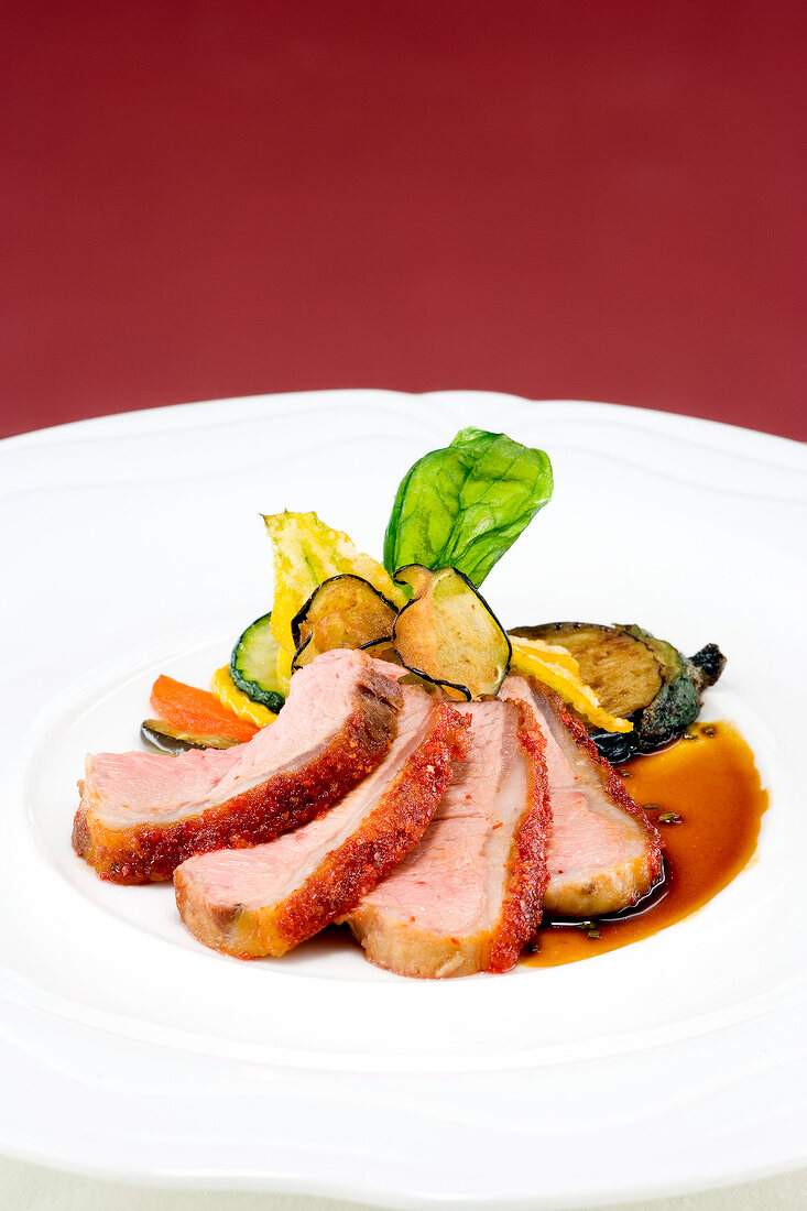 Pieces of lamb with peppers, ginger and vegetables on plate