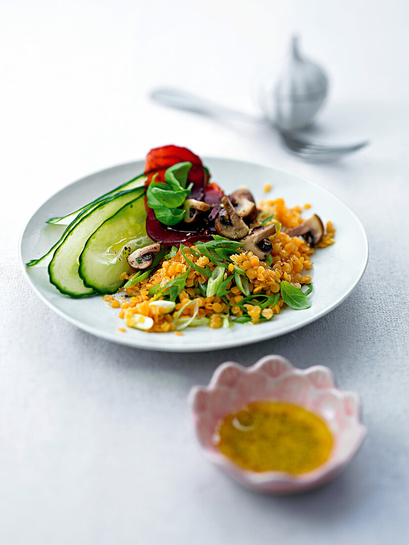 Salad with lentil, mushroom, vegetables and herbs on white plate