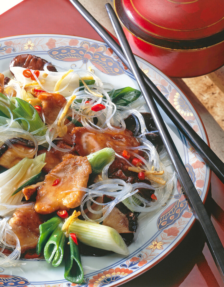 Close-up of pork with cellophane noodles on plate with chopsticks