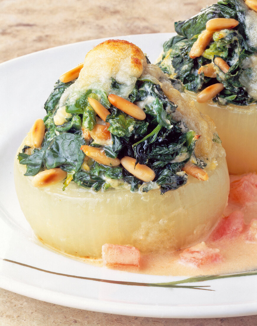 Close-up of onion with spinach filling and cheese on plate