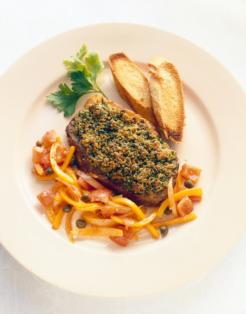 Rump steak with vegetables, bread and herb on plate